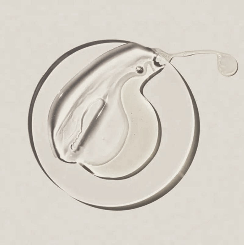 A swirl of clear and golden balm on a glass dish
